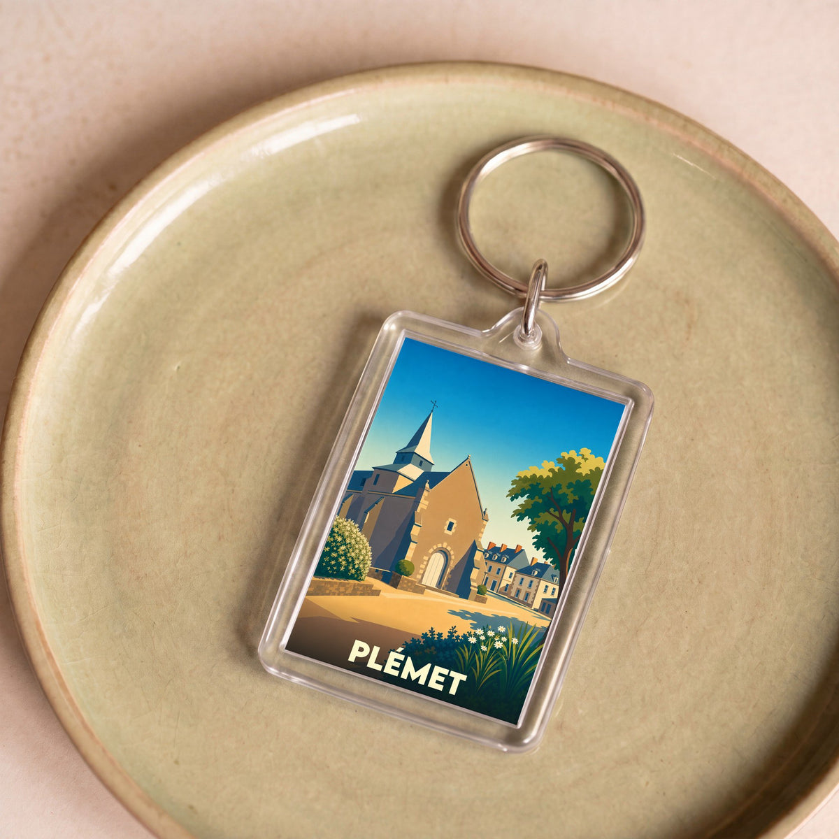 Porte-clés souvenir de la ville de Plémet avec une illustration stylisée de son église.