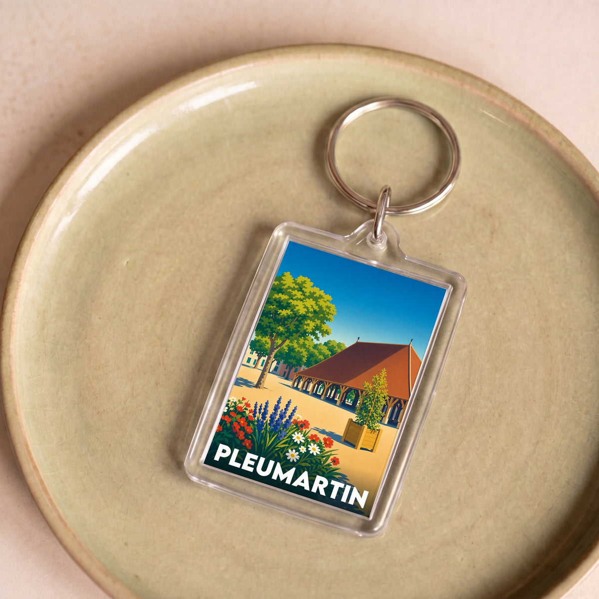 Porte-clés souvenir de la ville de Pleumartin avec une illustration stylisée.