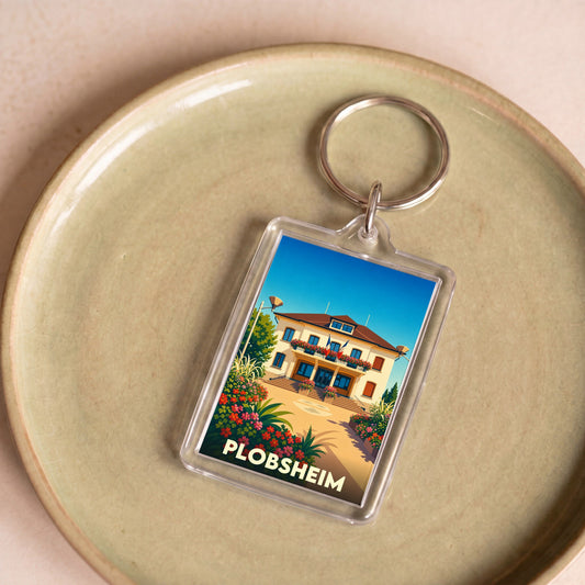Porte-clés souvenir de la ville de Plobsheim avec une illustration stylisée de sa mairie fleurie.
