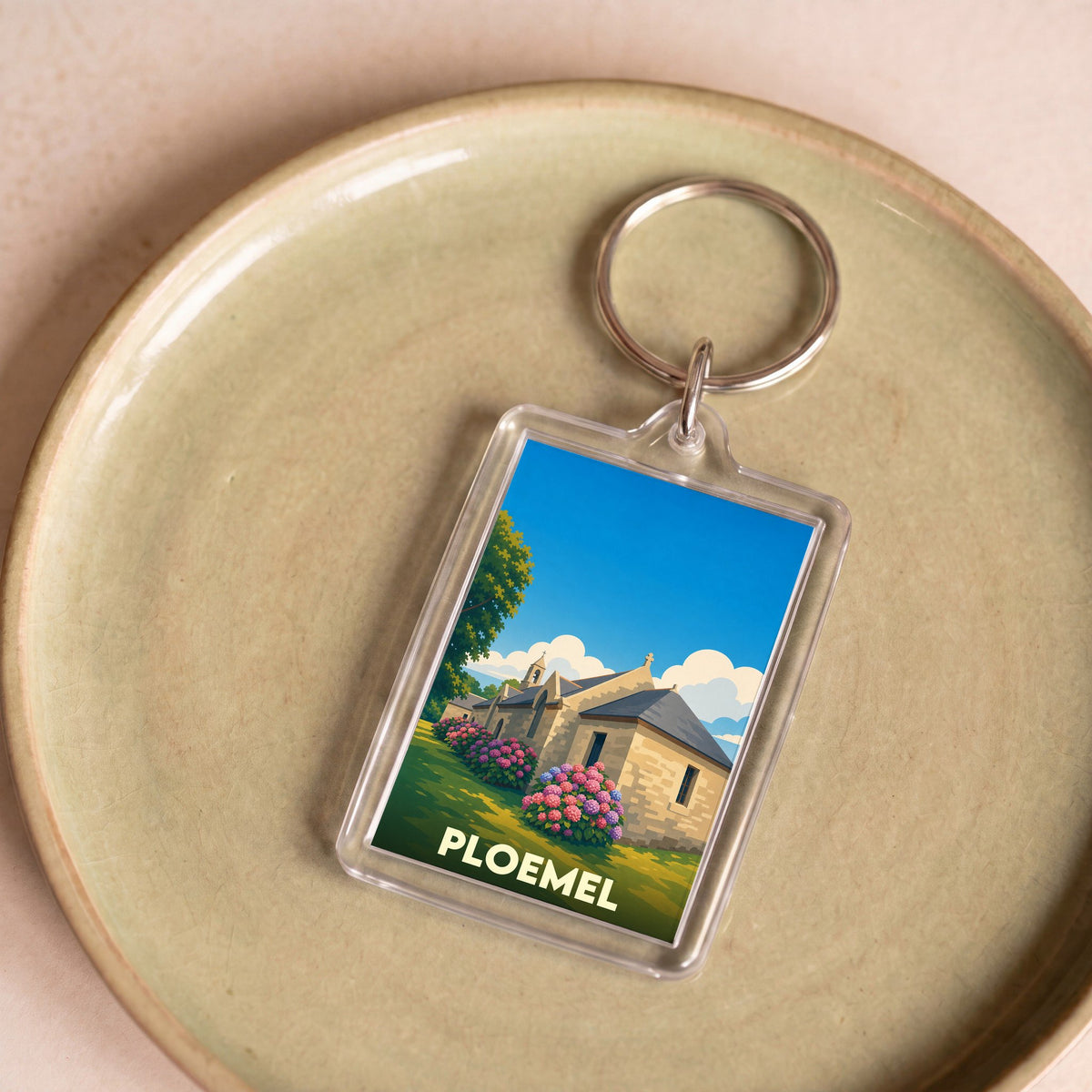 Porte-clés souvenir de la ville de Ploemel avec une illustration stylisée d'une chapelle bretonne.