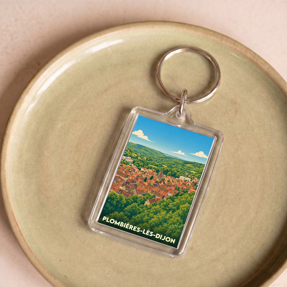 Porte-clés souvenir de la ville de Plombières-lès-Dijon avec une illustration stylisée.