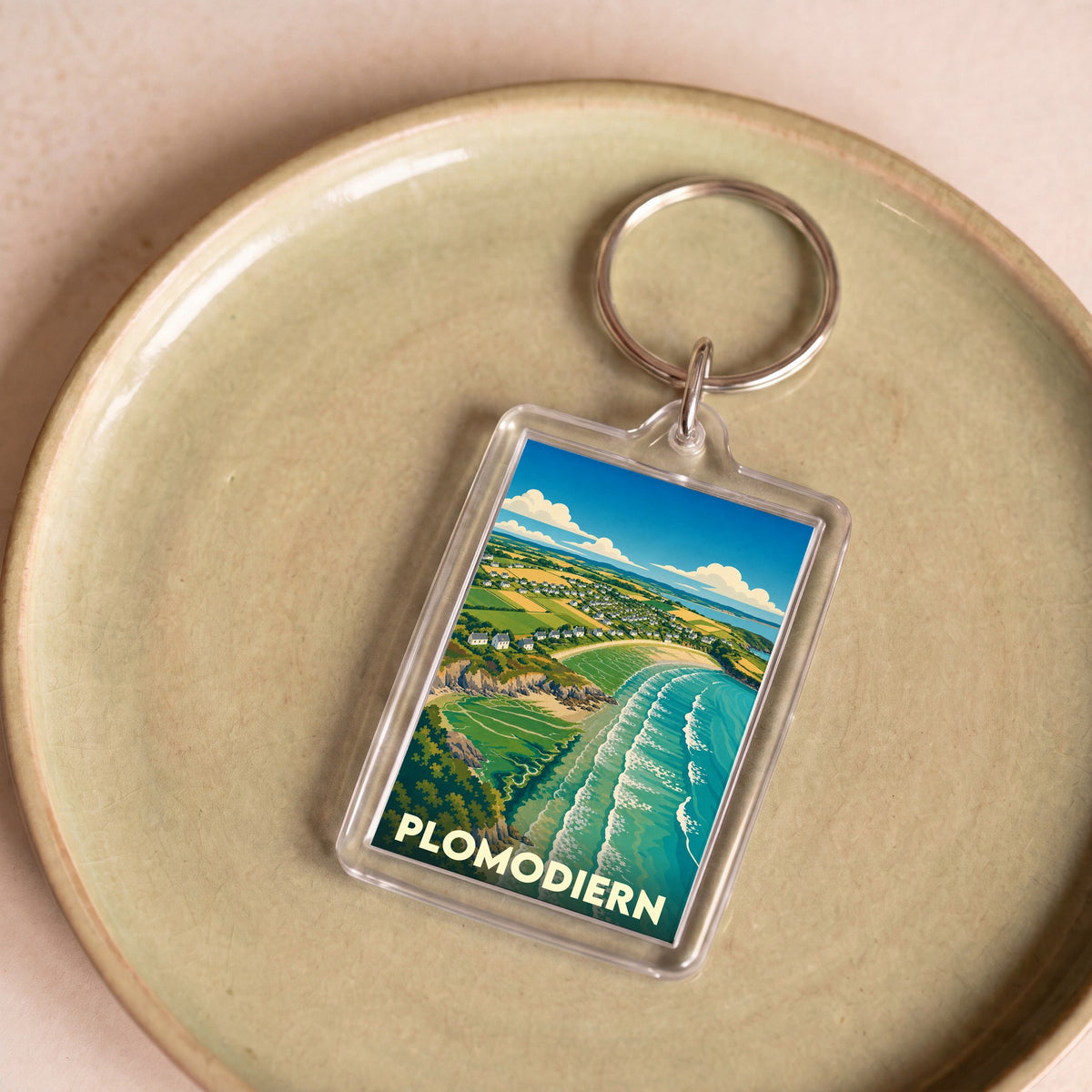 Porte-clés souvenir de la ville de Plomodiern avec une illustration stylisée de son paysage côtier.