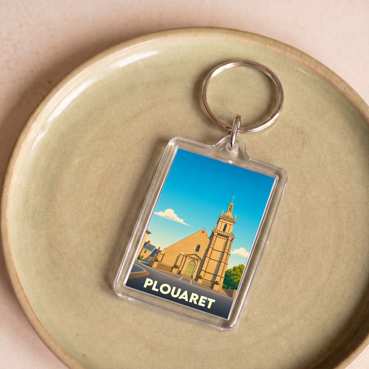 Porte-clés souvenir de la ville de Plouaret avec une illustration stylisée de son église.