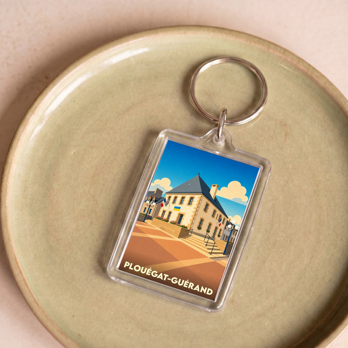 Porte-clés souvenir de la ville de Plouégat-Guérand avec une illustration stylisée de sa mairie.