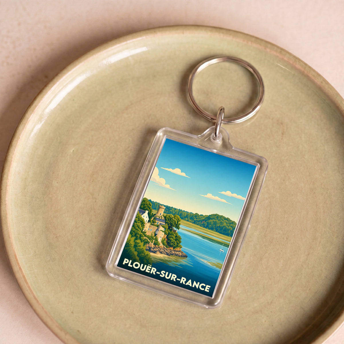 Porte-clés souvenir de la ville de Plouër-sur-Rance avec une illustration stylisée.