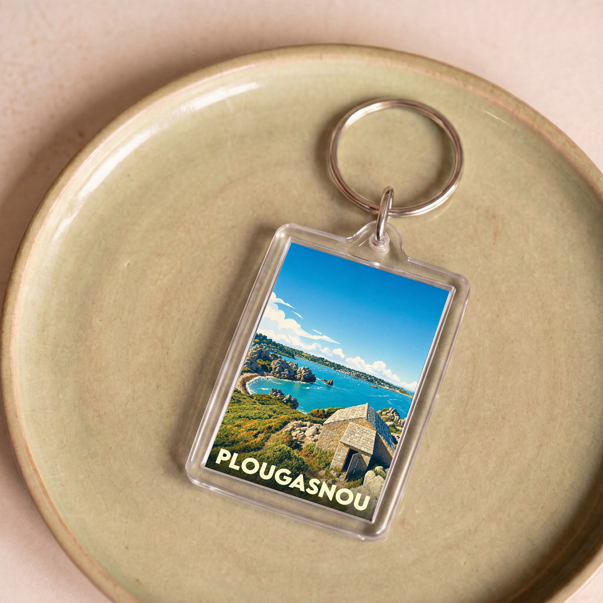 Porte-clés souvenir de la ville de Plougasnou avec une illustration stylisée du littoral breton.