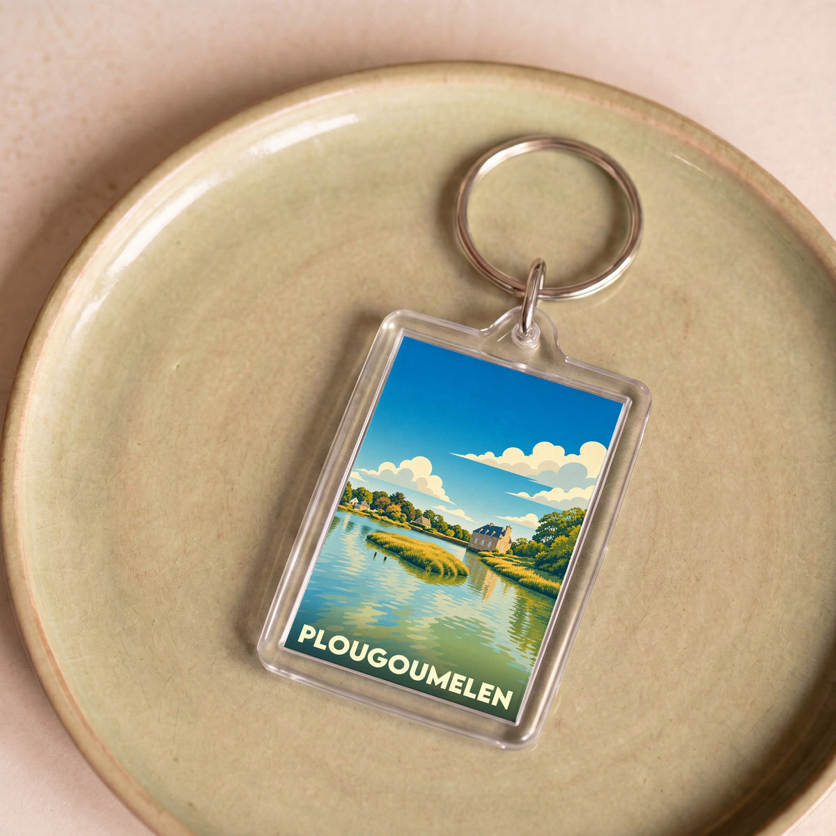 Porte-clés souvenir de la ville de Plougoumelen avec une illustration stylisée d'un paysage côtier.