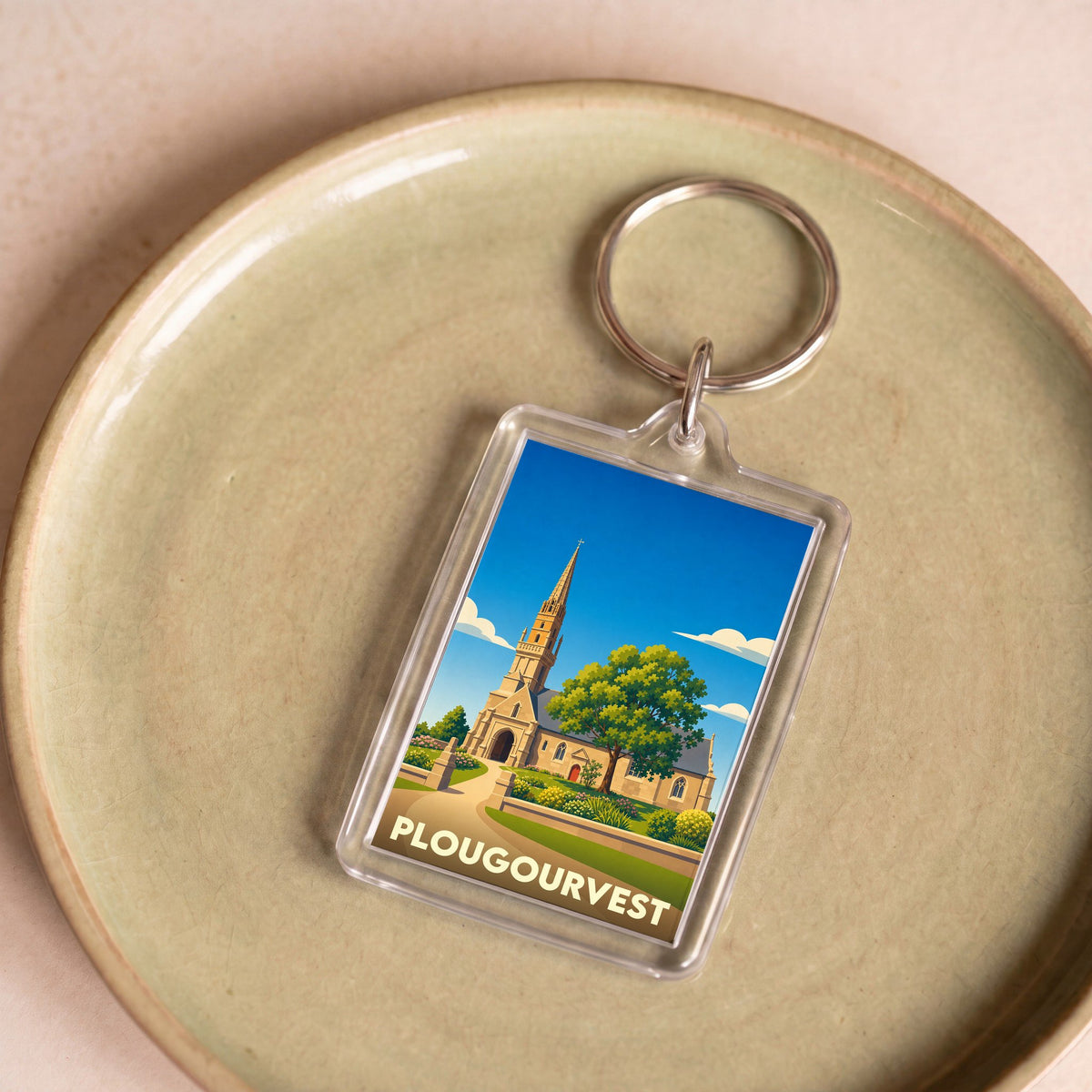 Porte-clés souvenir de la ville de Plougourvest avec une illustration stylisée de son église.