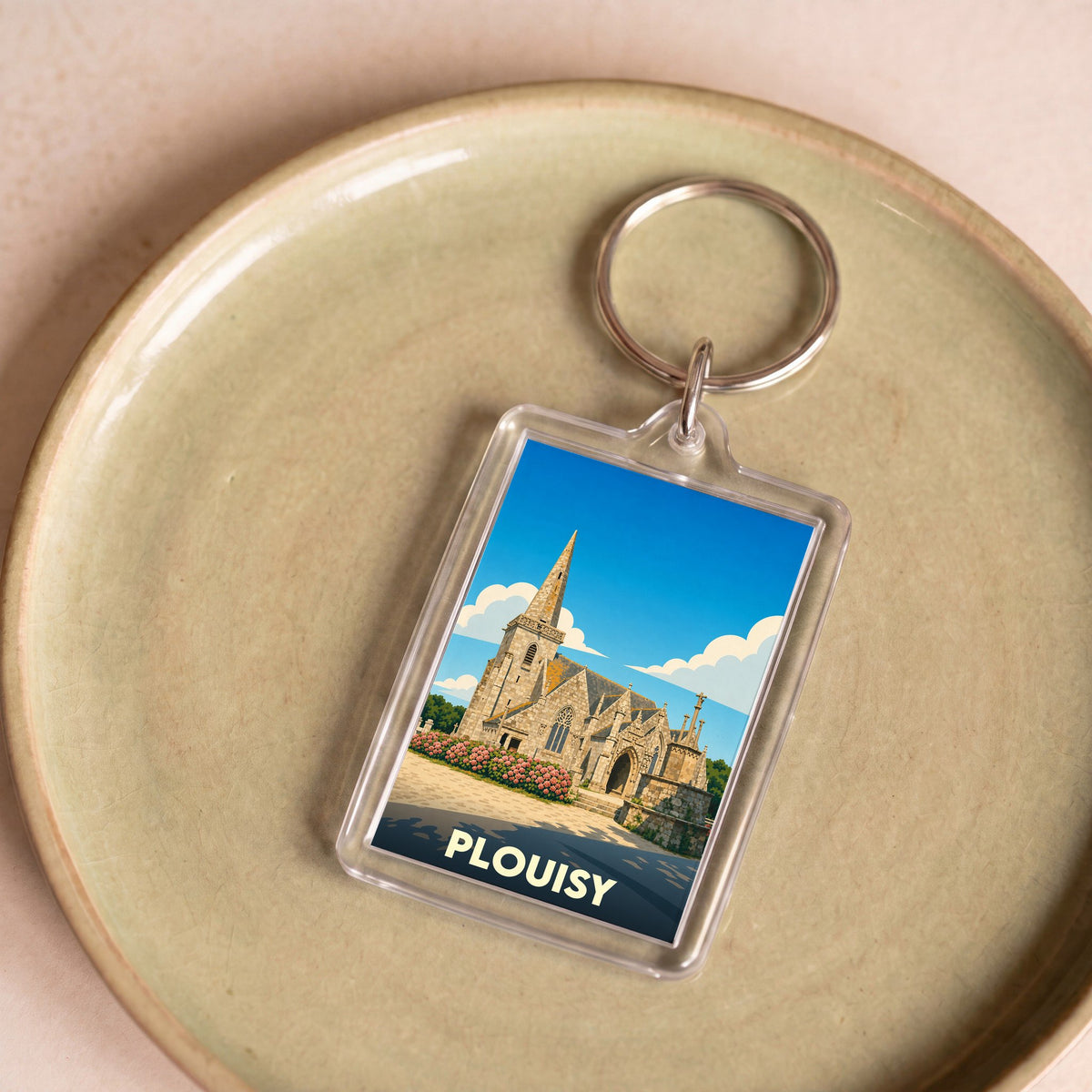 Porte-clés souvenir de la ville de Plouisy avec une illustration stylisée de son église.