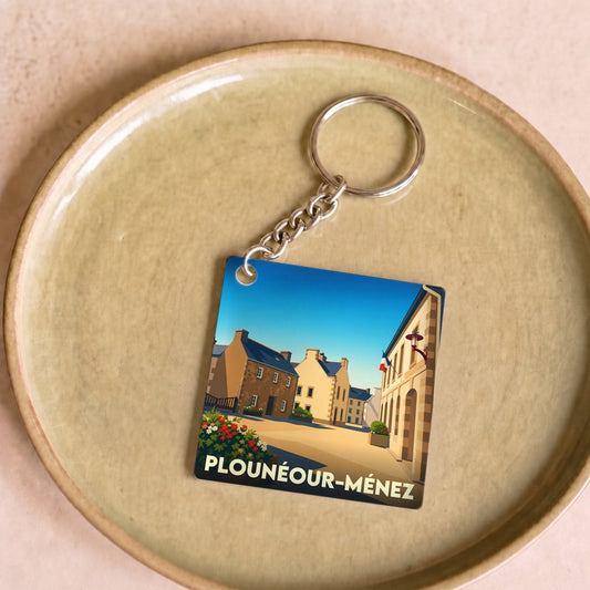 Porte-clés souvenir de la ville de Plounéour-Ménez avec une illustration stylisée.