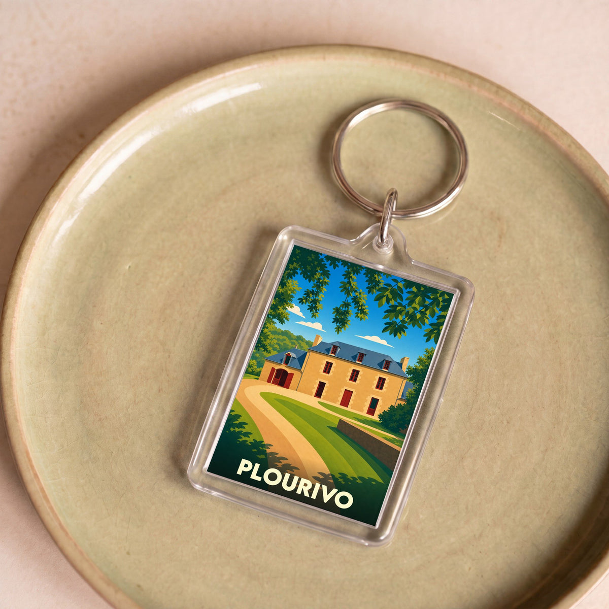 Porte-clés souvenir de la ville de Plourivo avec une illustration stylisée d'un manoir breton.