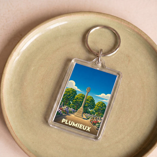 Porte-clés souvenir de la ville de Plumieux avec une illustration stylisée d'un monument historique.