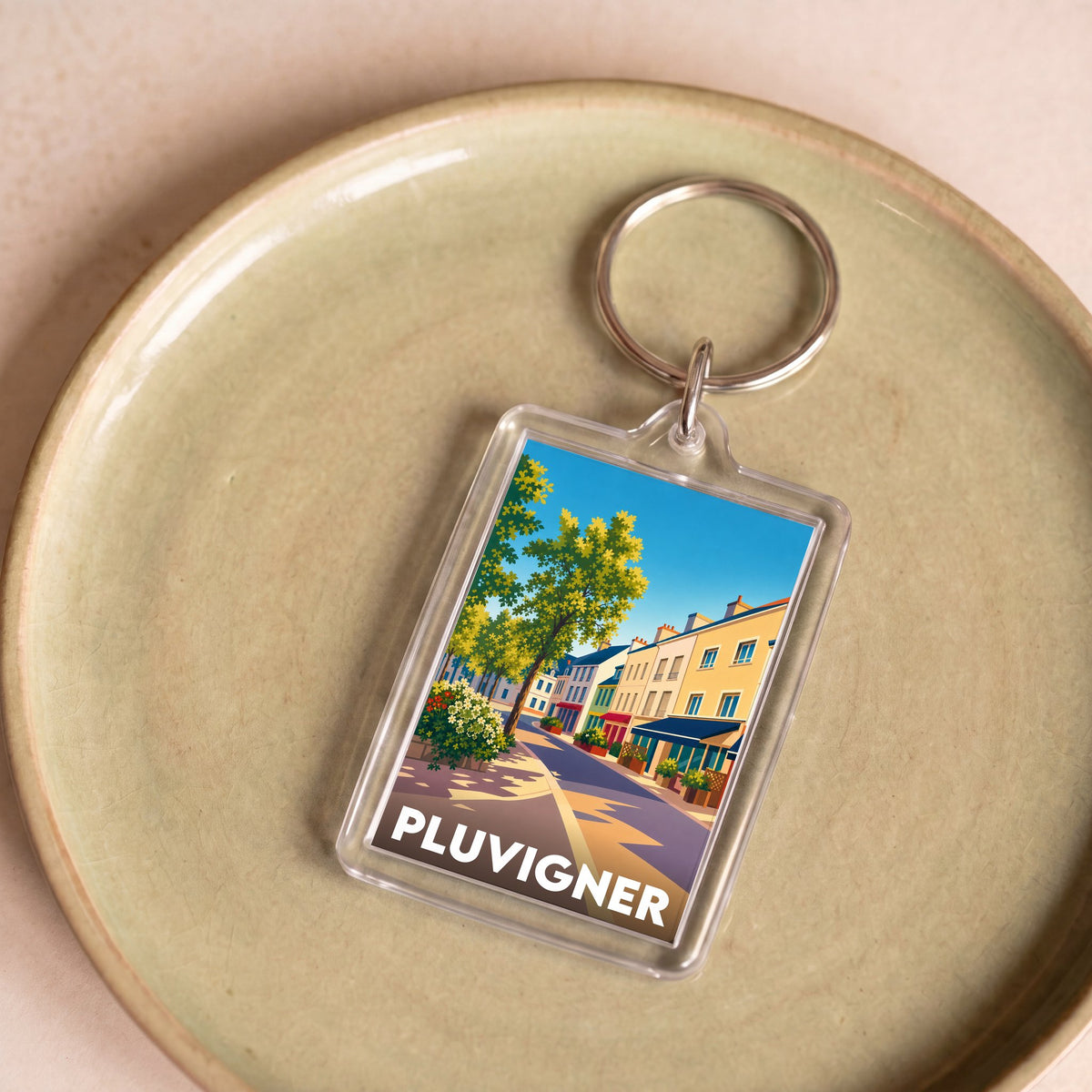 Porte-clés souvenir de la ville de Pluvigner avec une illustration colorée et stylisée.