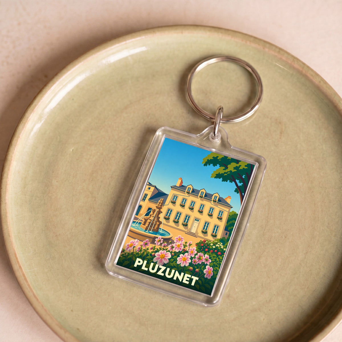 Porte-clés souvenir de la ville de Pluzunet avec une illustration colorée et stylisée.
