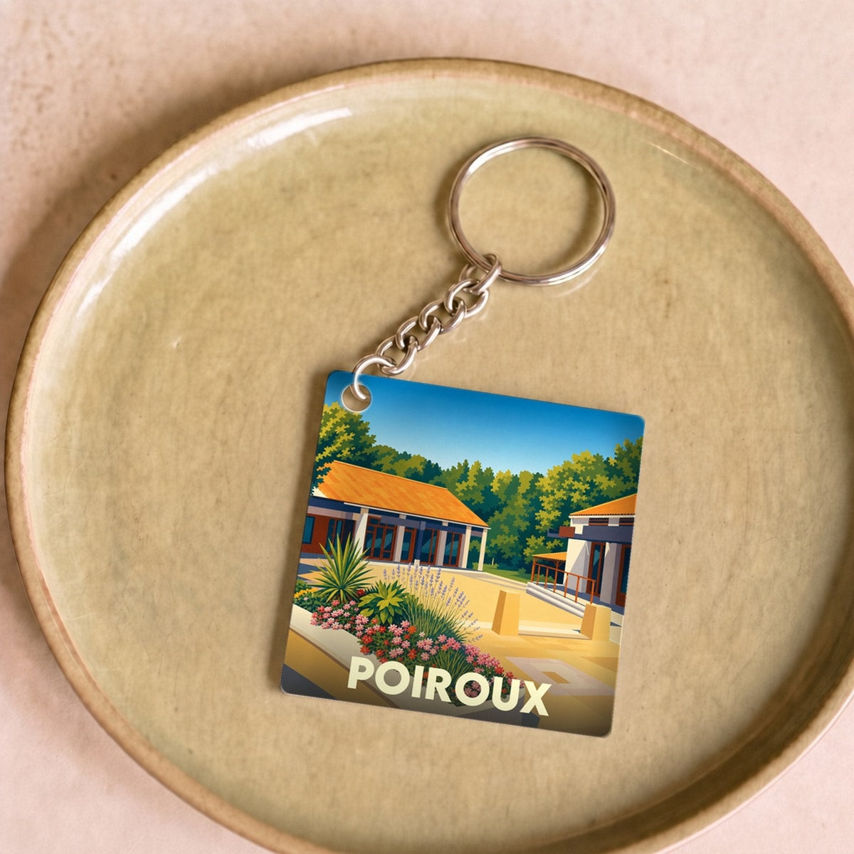 Porte-clés souvenir de la ville de Poiroux avec une illustration stylisée et colorée.