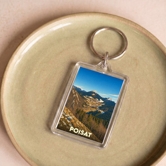 Porte-clés souvenir de la ville de Poisat avec une photographie de paysage montagneux.