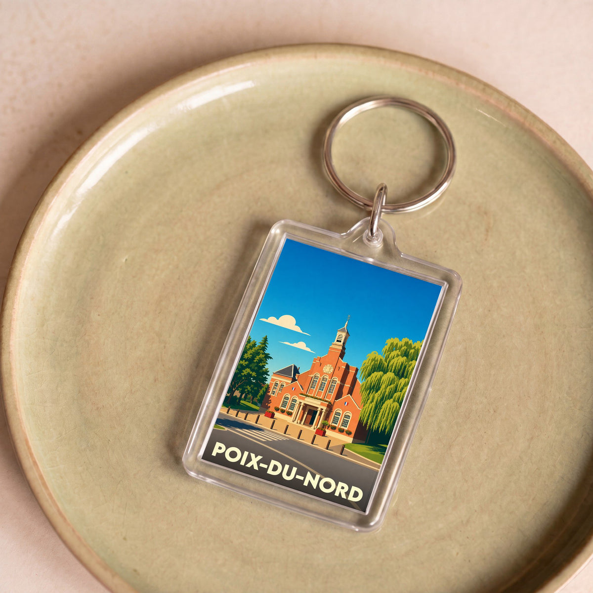 Porte-clés souvenir de la ville de Poix-du-Nord avec une illustration stylisée de son hôtel de ville.