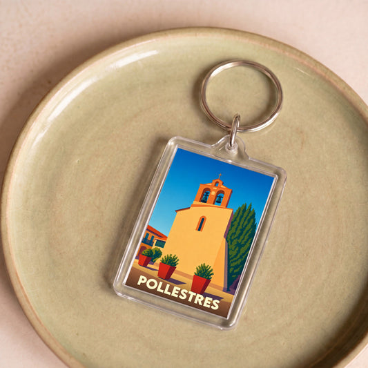 Porte-clés souvenir de la ville de Pollestres avec une illustration stylisée de son église.