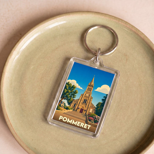Porte-clés souvenir de la ville de Pommeret avec une illustration stylisée de son église.