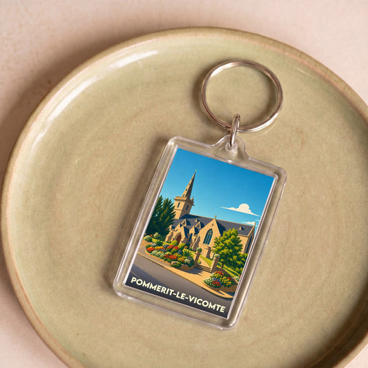 Porte-clés souvenir de la ville de Pommerit-le-Vicomte avec une illustration stylisée de son église et de ses jardins fleuris.