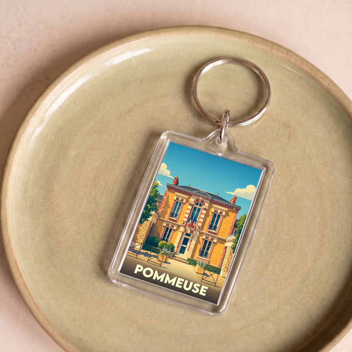 Porte-clés souvenir de la ville de Pommeuse avec une illustration stylisée de sa mairie.