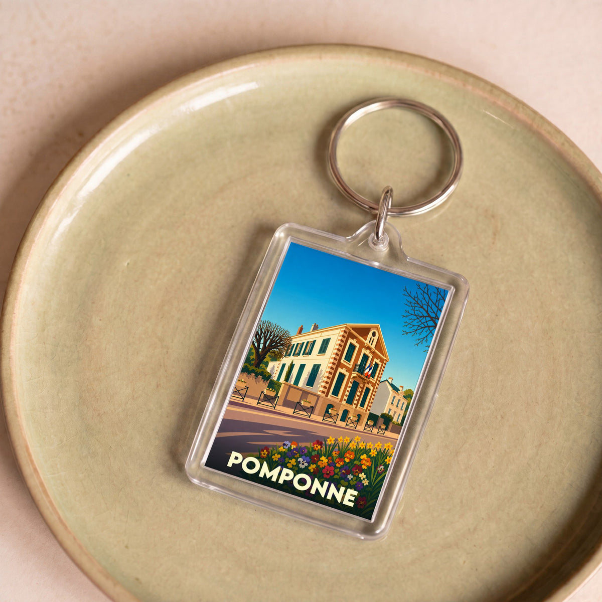 Porte-clés souvenir de la ville de Pomponne avec une illustration colorée et stylisée.