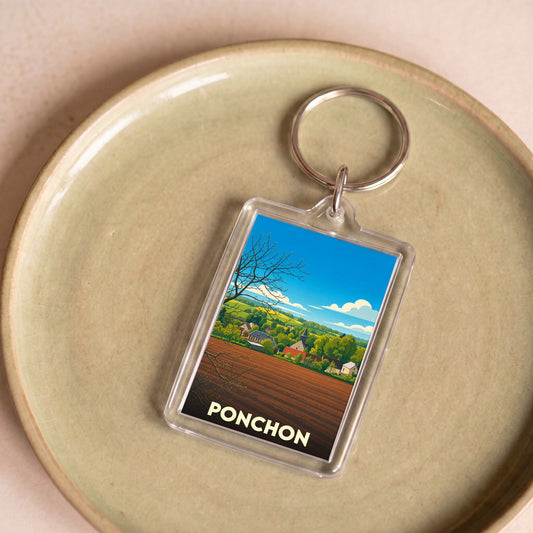 Porte-clés souvenir de la ville de Ponchon avec une illustration stylisée de son paysage rural.