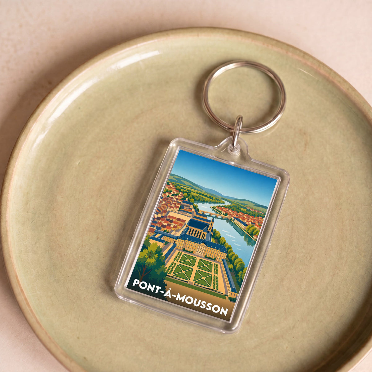 Porte-clés souvenir de la ville de Pont-à-Mousson avec une illustration stylisée et colorée.