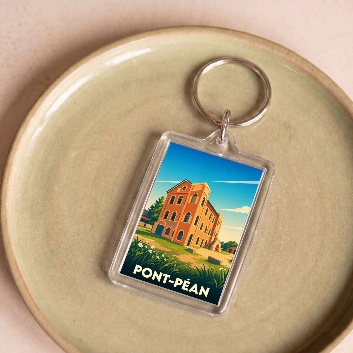 Porte-clés souvenir de la ville de Pont-Péan avec une illustration stylisée d'un bâtiment historique.