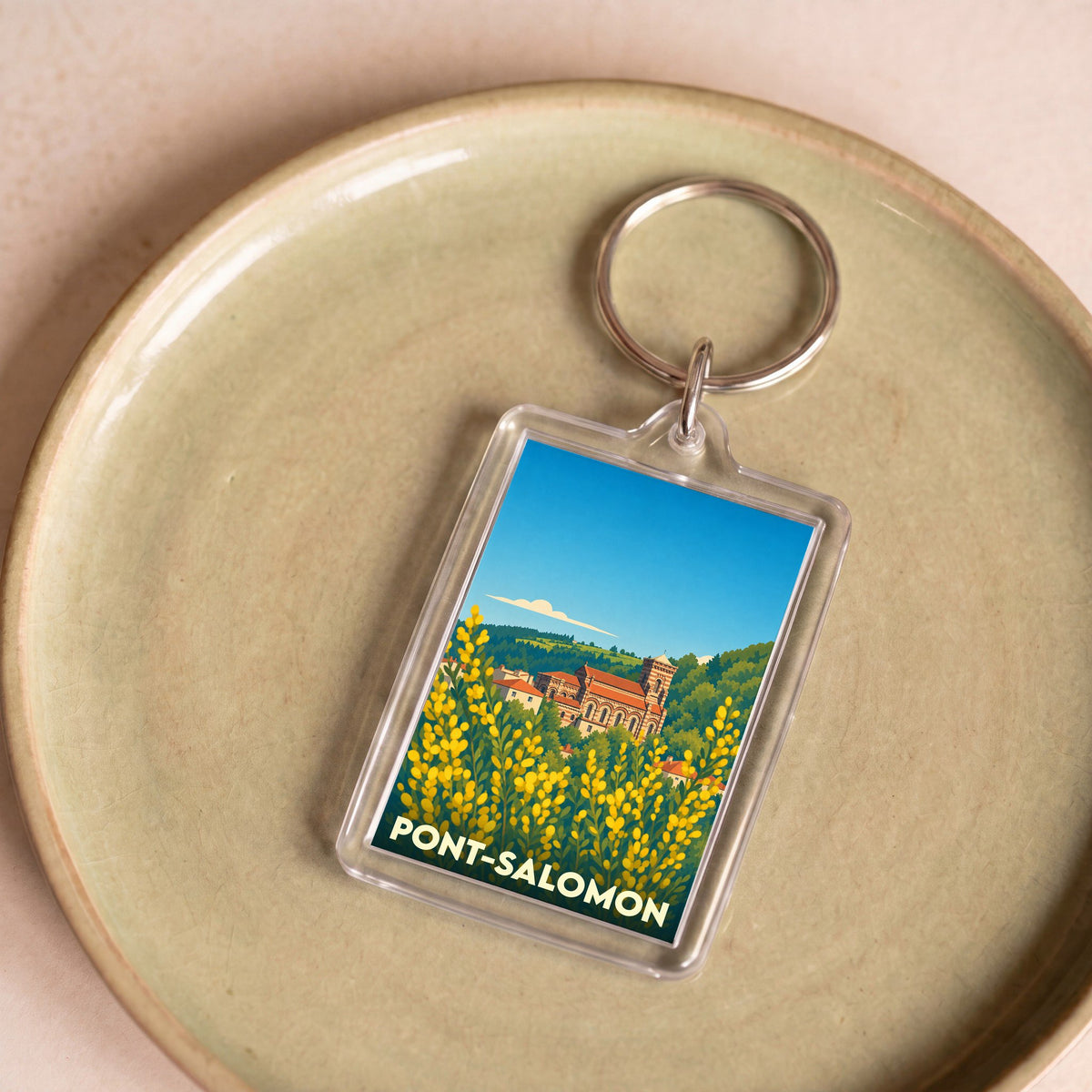 Porte-clés souvenir de la ville de Pont-Salomon avec une illustration stylisée d'un paysage local.