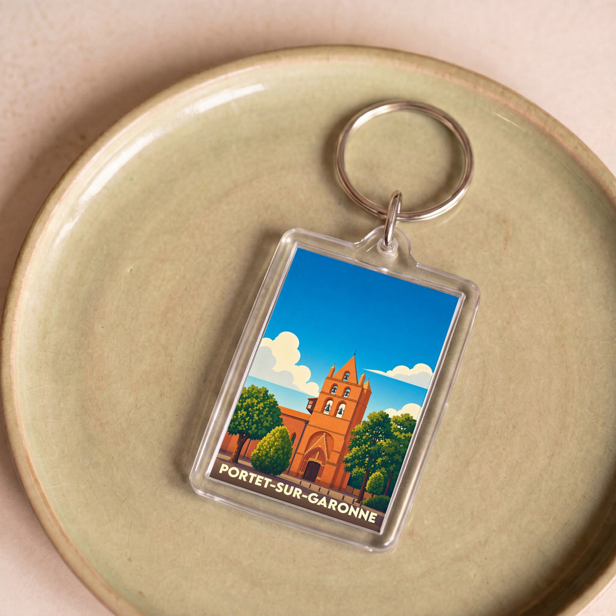 Porte-clés souvenir de la ville de Portet-sur-Garonne avec une illustration stylisée de son église.