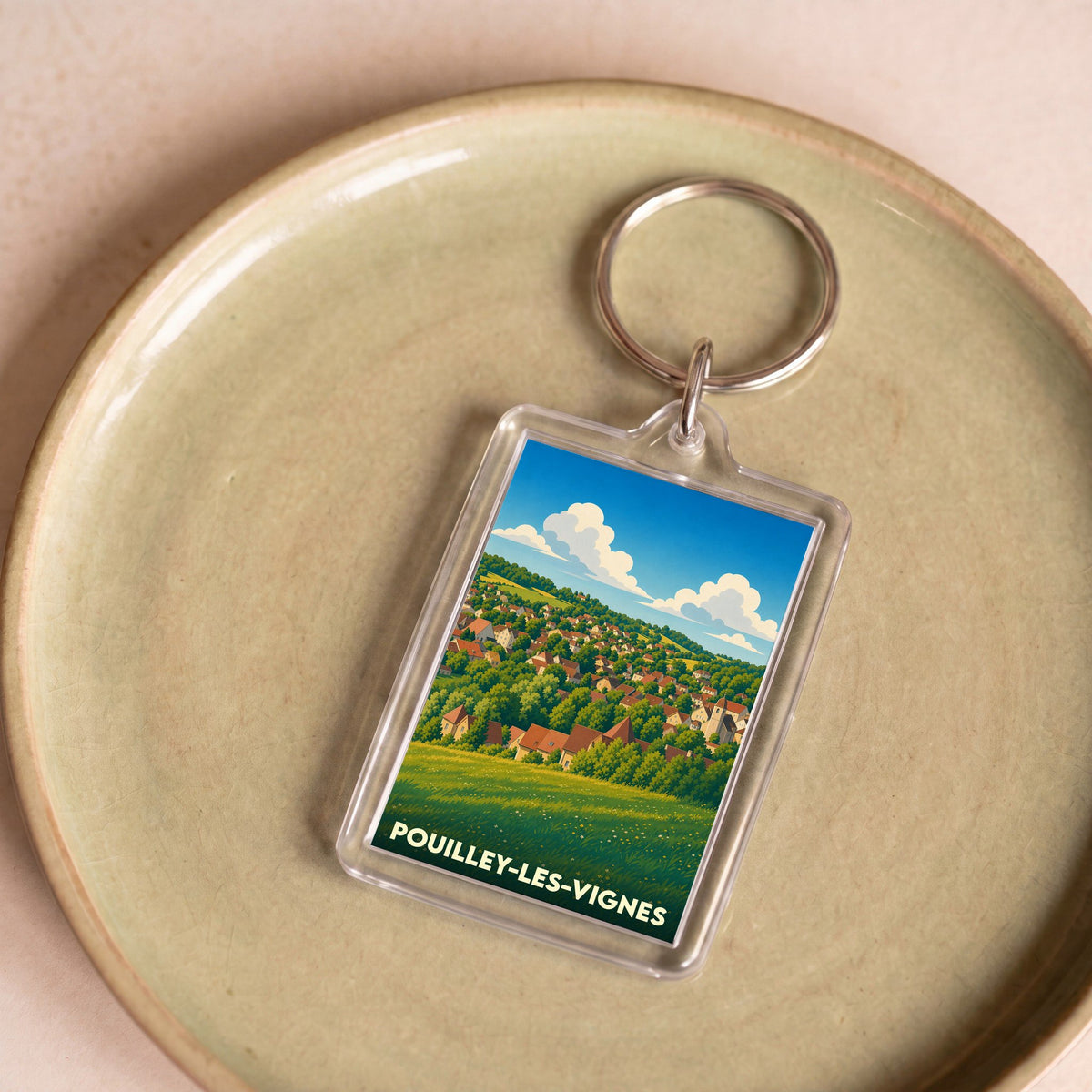 Porte-clés souvenir de la ville de Pouilley-les-Vignes avec une illustration stylisée.