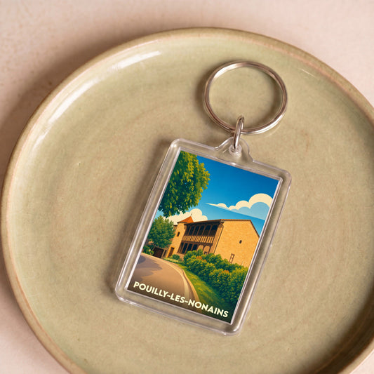 Porte-clés souvenir de la ville de Pouilly-les-Nonains avec une illustration stylisée.
