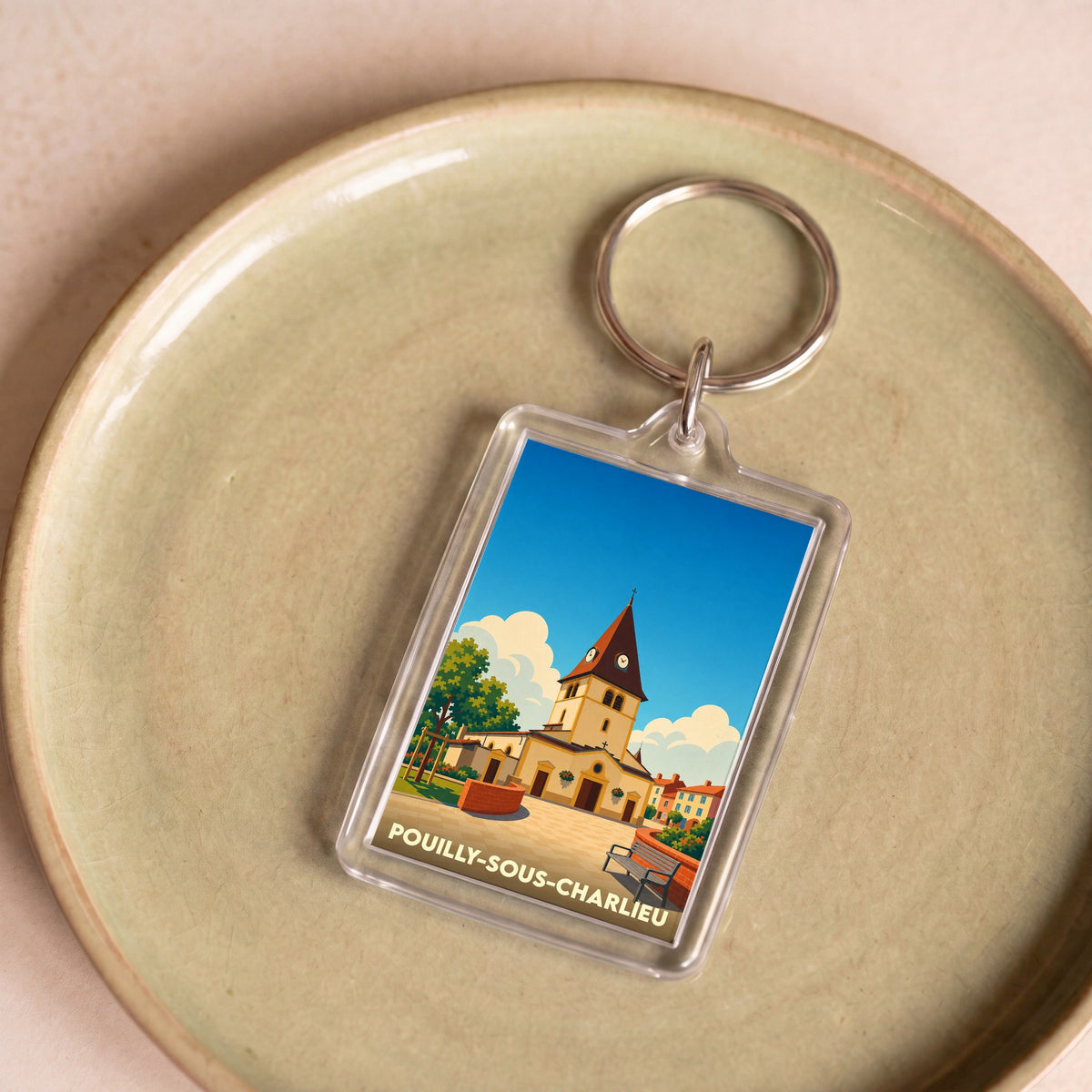 Porte-clés souvenir de la ville de Pouilly-sous-Charlieu avec une illustration stylisée de son église.