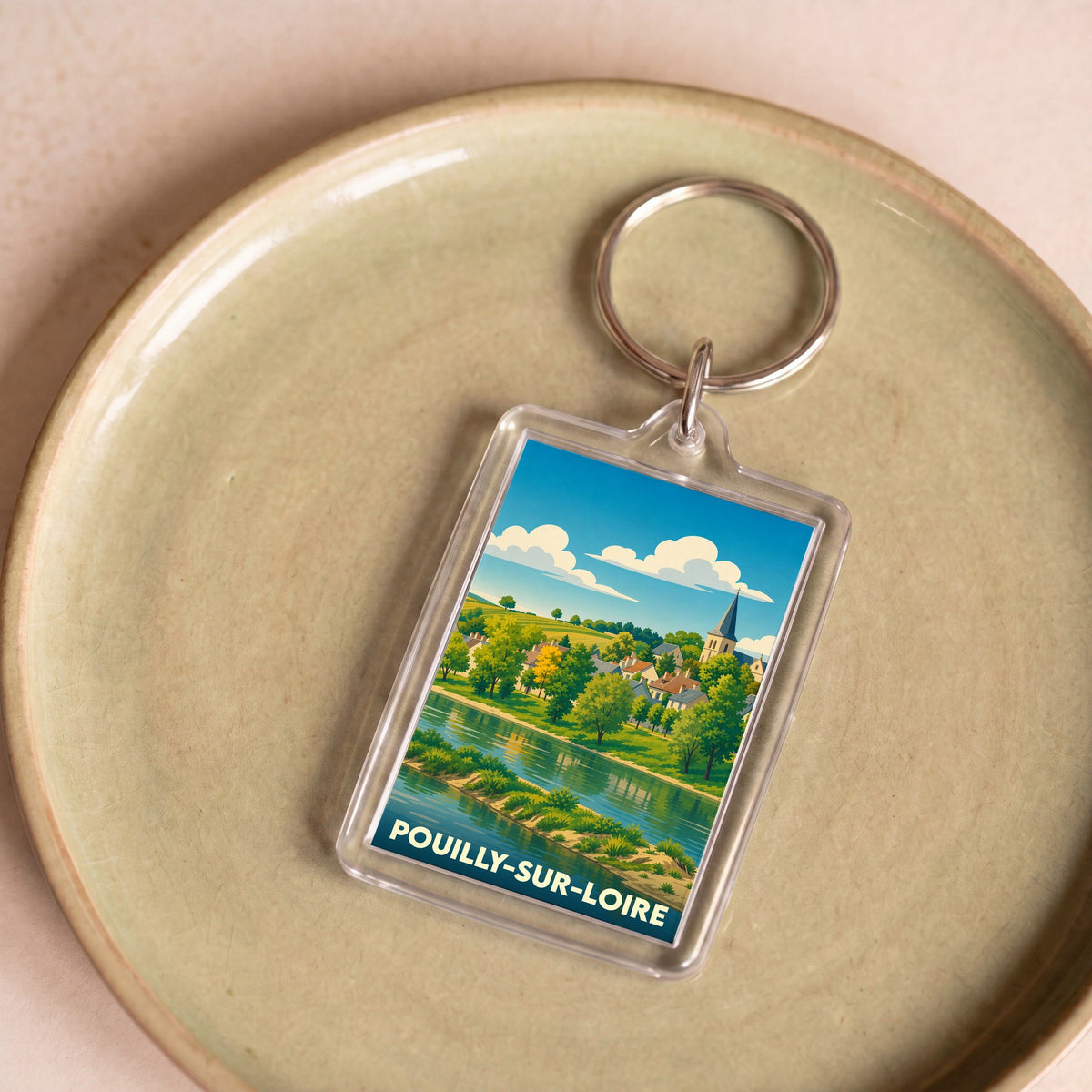 Porte-clés souvenir de la ville de Pouilly-sur-Loire avec une illustration stylisée des bords de Loire.