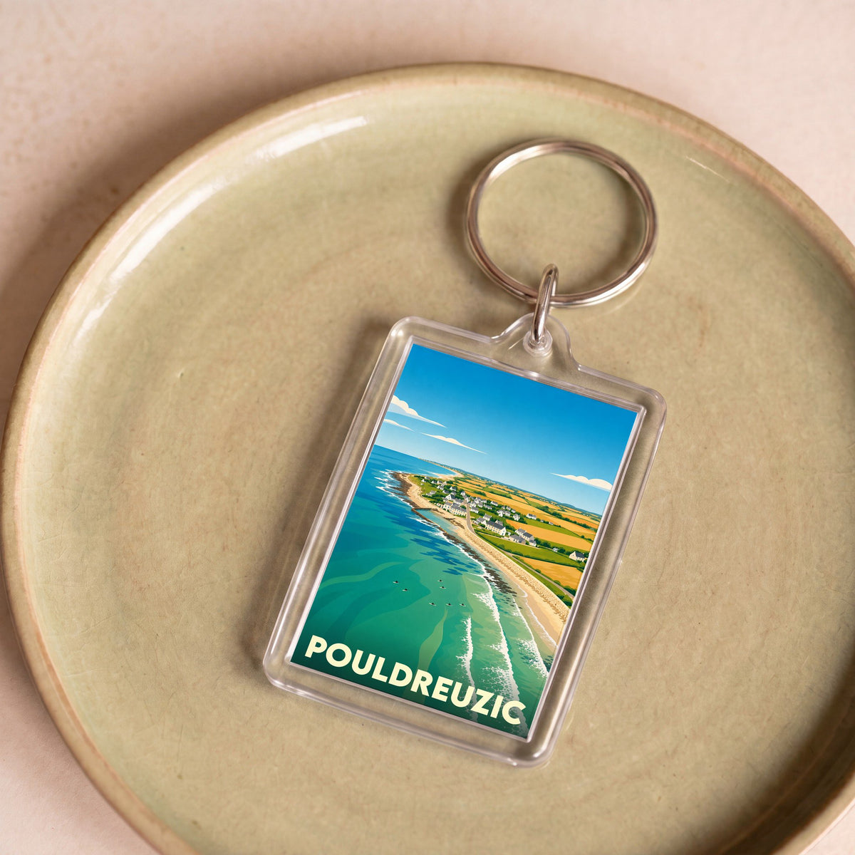 Porte-clés souvenir de la ville de Pouldreuzic avec une illustration stylisée de son littoral.