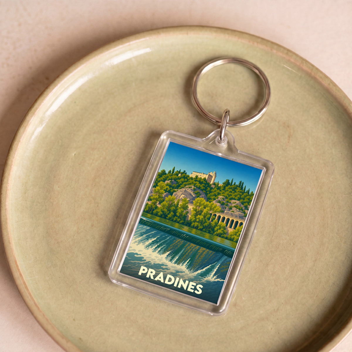 Porte-clés souvenir de la ville de Pradines avec une illustration stylisée d'un paysage fluvial.