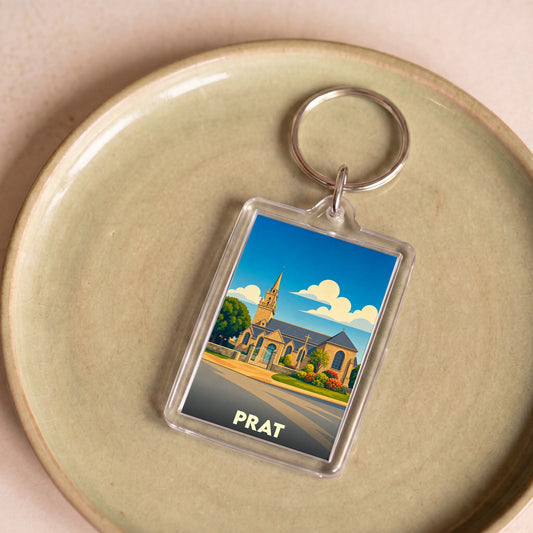 Porte-clés souvenir de la ville de Prat avec une illustration stylisée d'une église sous un ciel bleu.