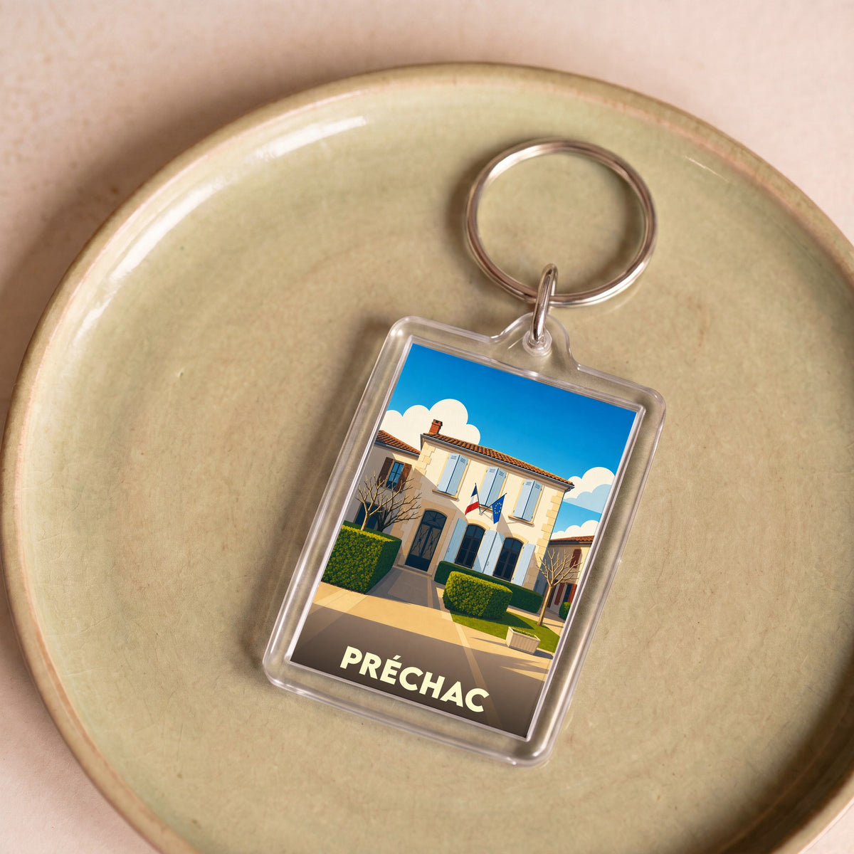 Porte-clés souvenir de la ville de Préchac avec une illustration stylisée.