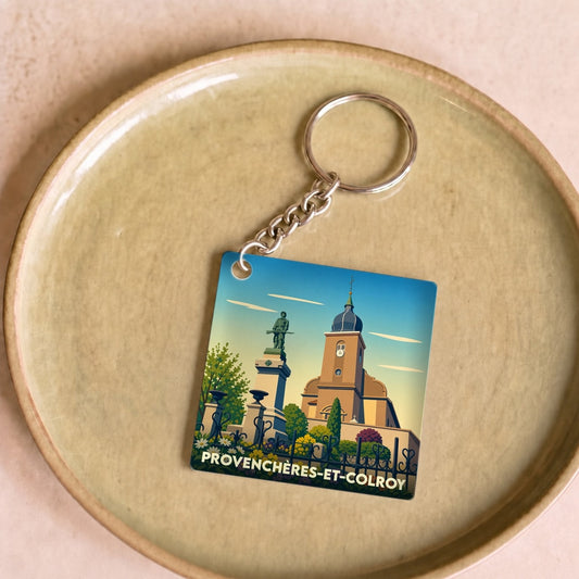 Porte-clés souvenir de la ville de Provenchères-et-Colroy avec une illustration stylisée de son église et d'un monument.