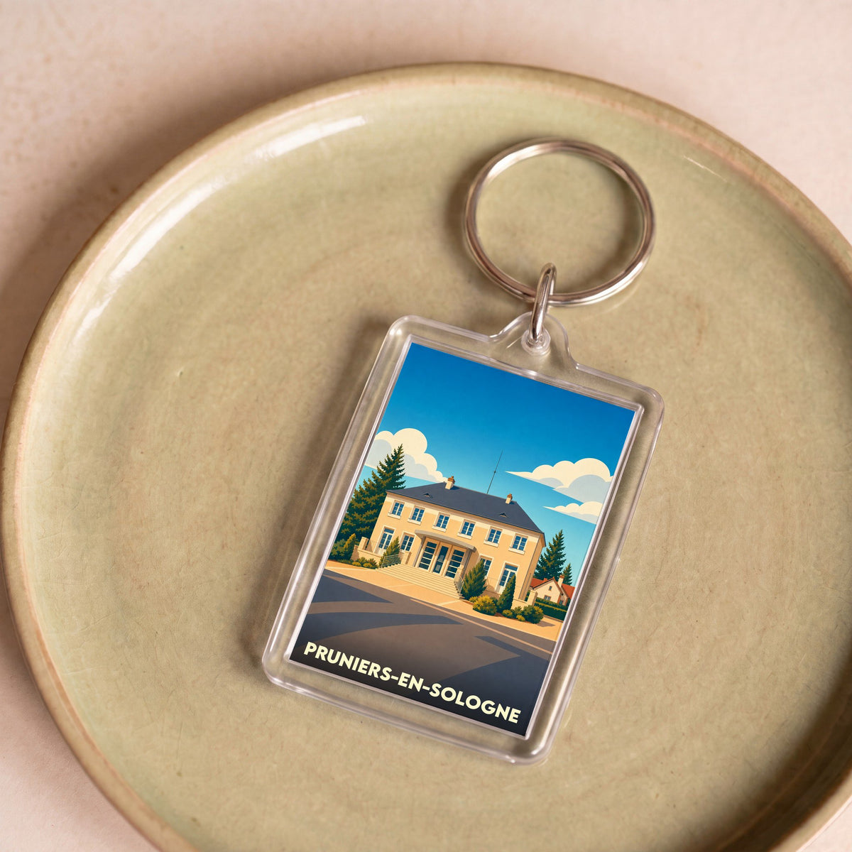 Porte-clés souvenir de la ville de Pruniers-en-Sologne avec une illustration stylisée.