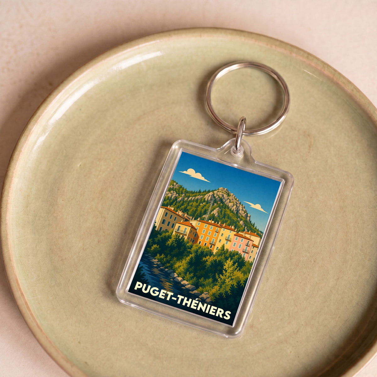 Porte-clés souvenir de la ville de Puget-Théniers avec une illustration stylisée.