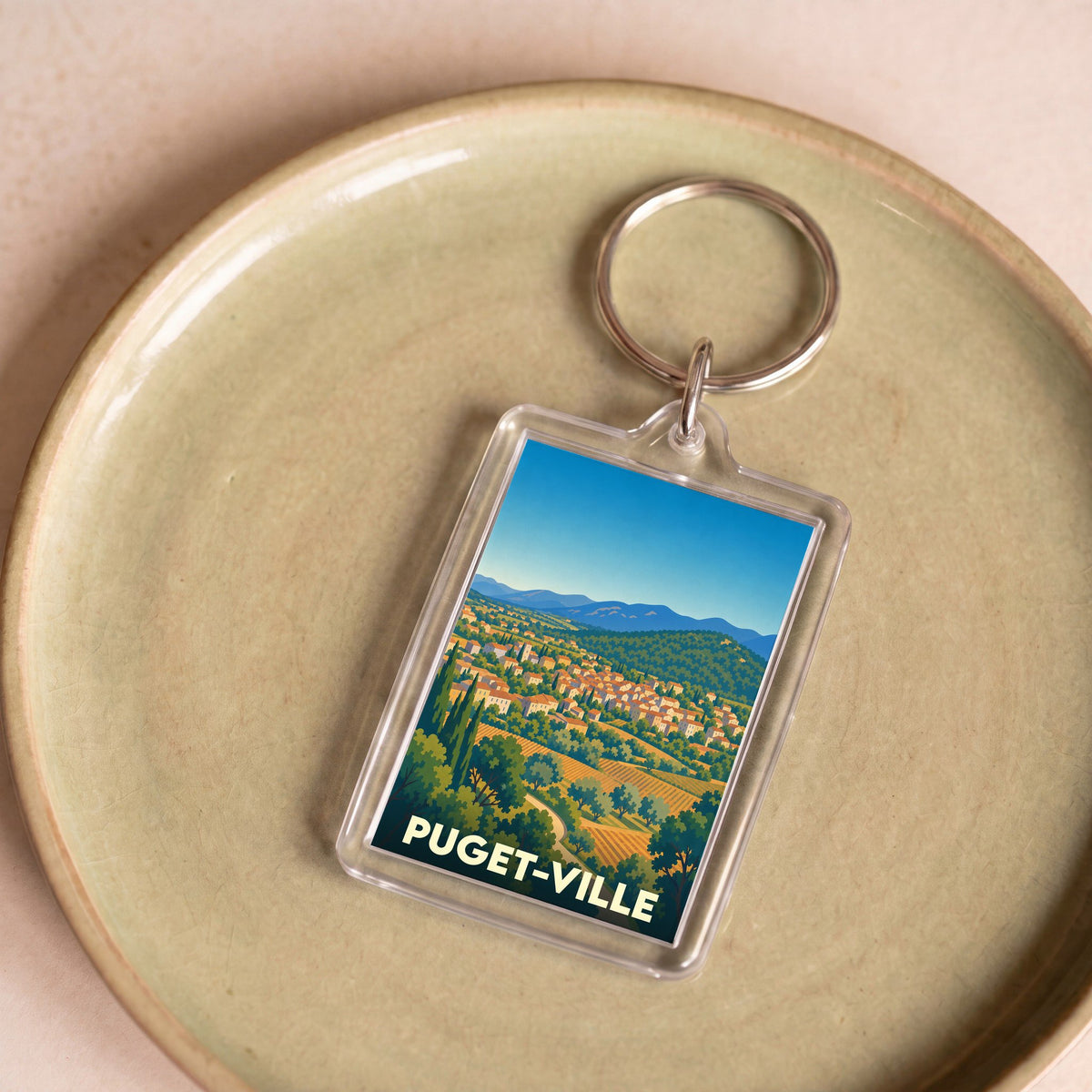 Porte-clés souvenir de la ville de Puget-Ville avec une illustration stylisée.