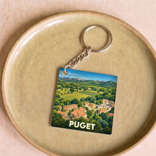 Porte-clés souvenir de la ville de Puget avec une illustration stylisée de son paysage provençal.