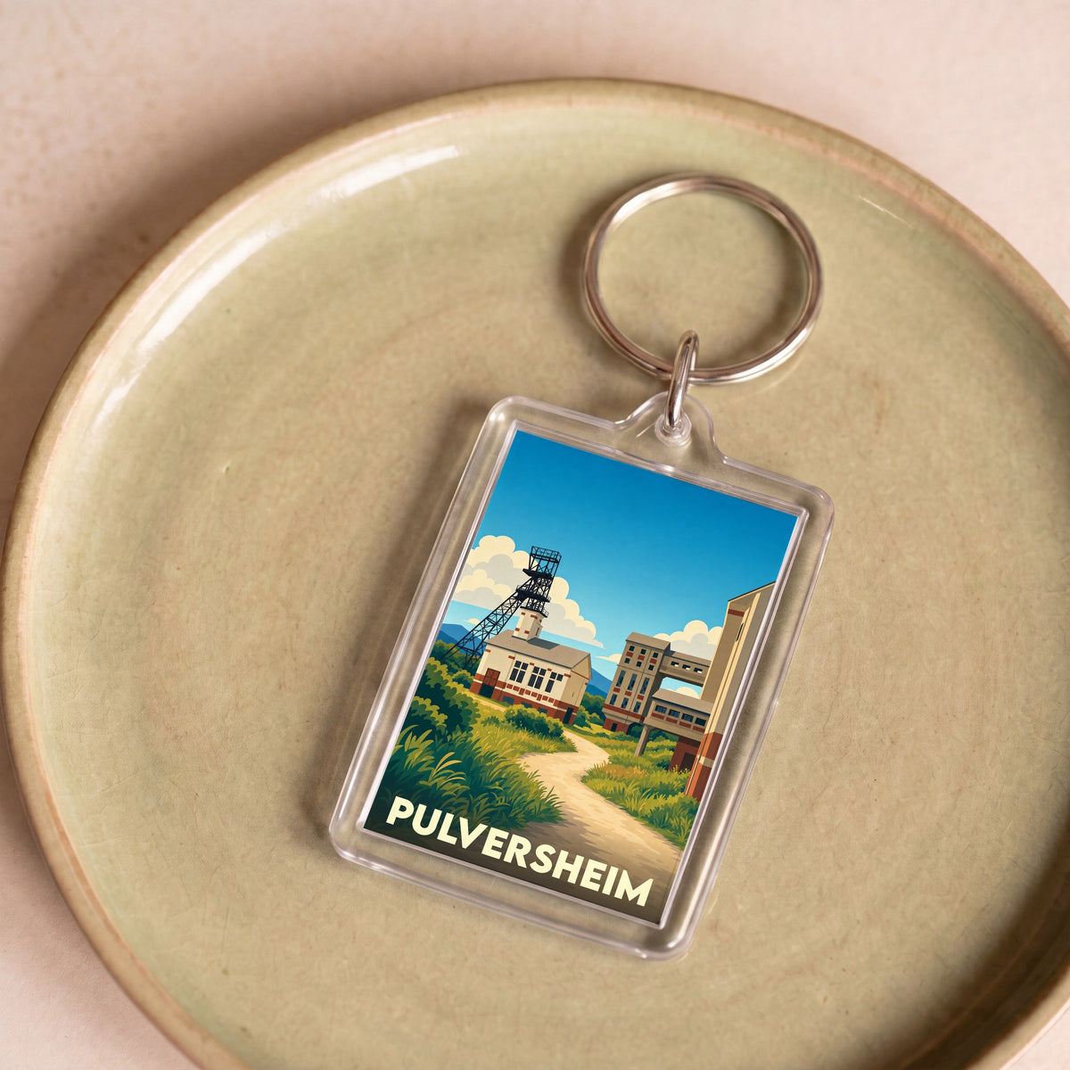 Porte-clés souvenir de la ville de Pulversheim avec une illustration stylisée de son patrimoine industriel.
