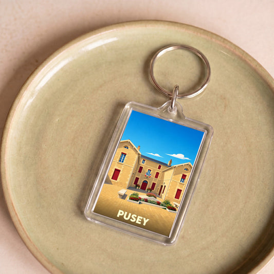 Porte-clés souvenir de la ville de Pusey avec une illustration stylisée de son hôtel de ville.