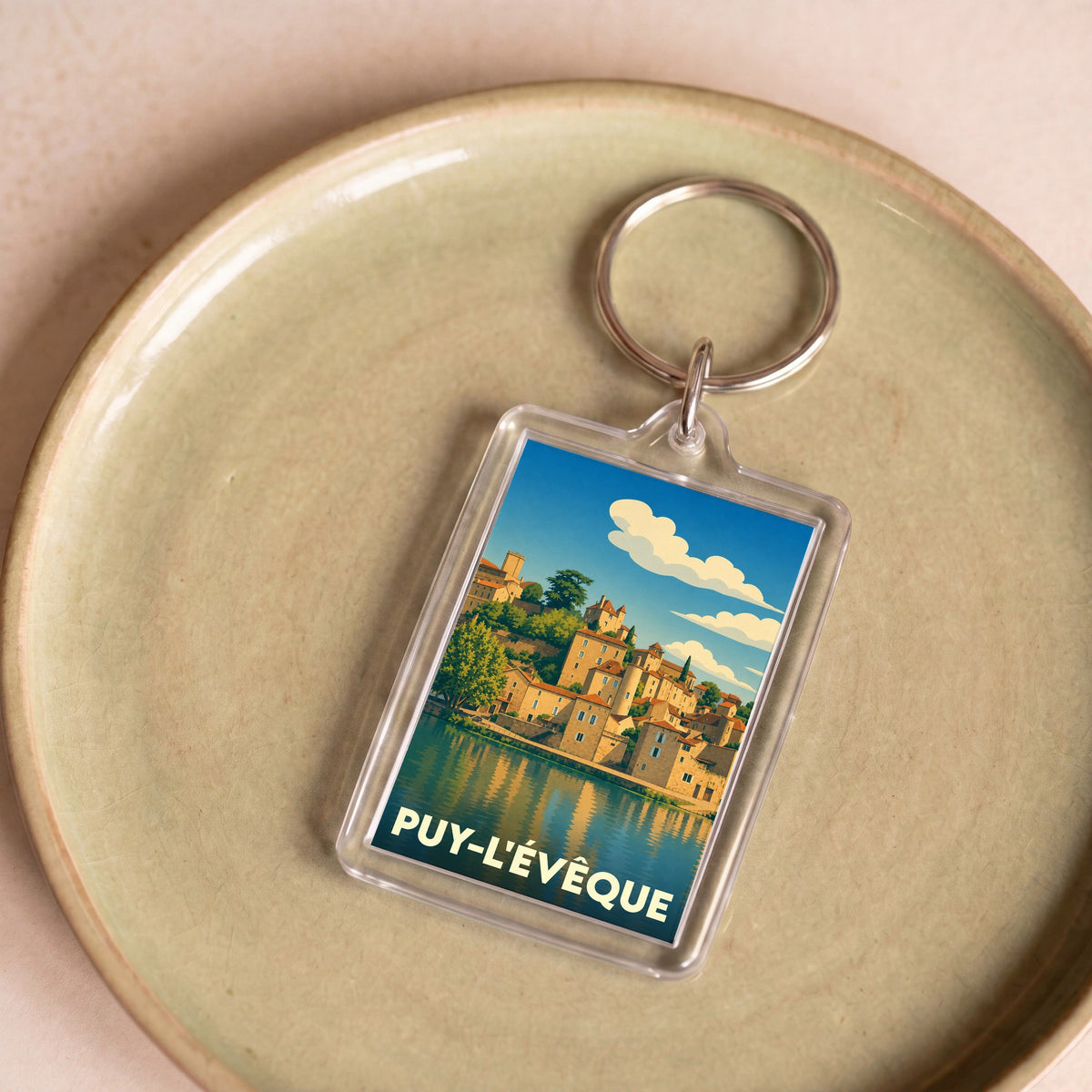 Porte-clés souvenir de la ville de Puy-l'Évêque avec une illustration stylisée.