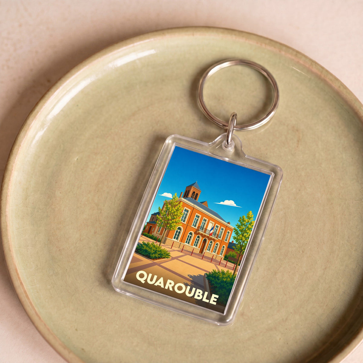 Porte-clés souvenir de la ville de Quarouble avec une illustration stylisée de son hôtel de ville.