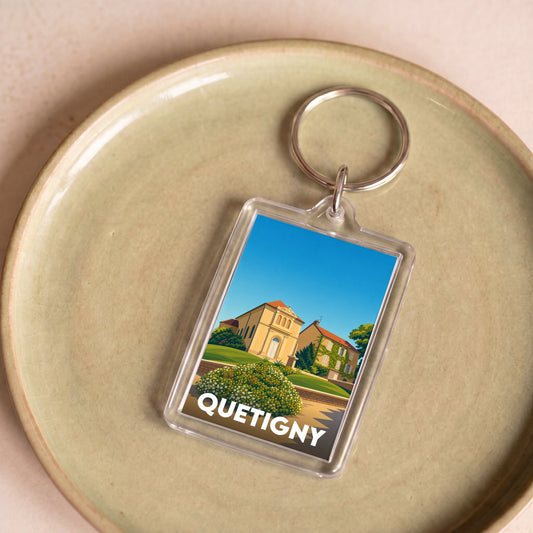 Porte-clés souvenir de la ville de Quetigny avec une illustration stylisée.