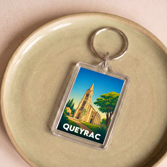 Porte-clés souvenir de la ville de Queyrac avec une illustration stylisée.
